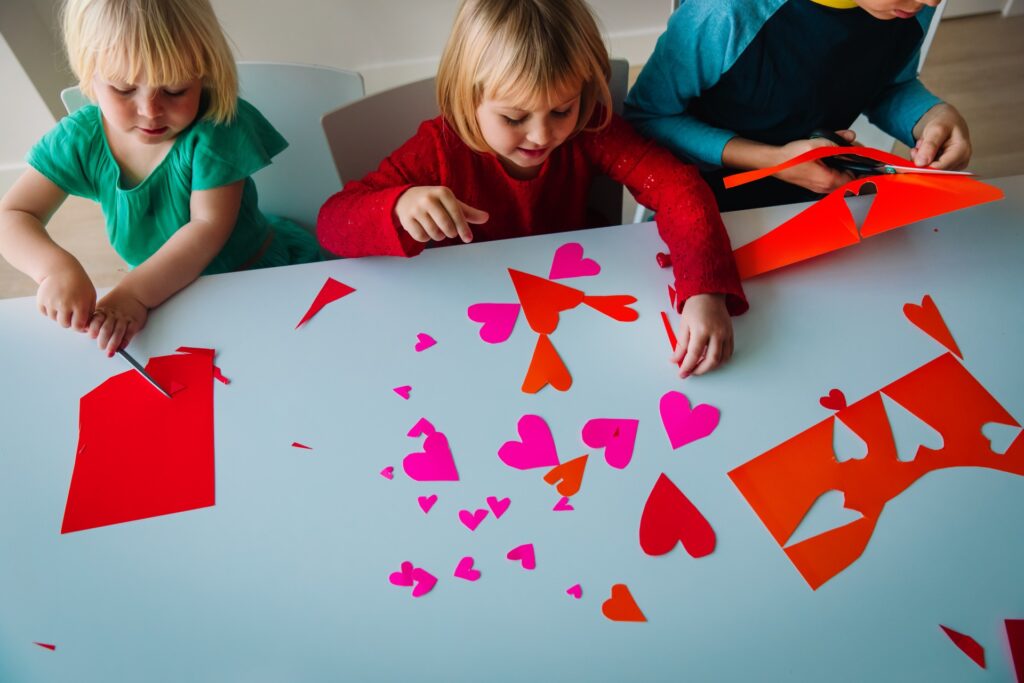 Kids cut out hearts for Valentine's Day at school