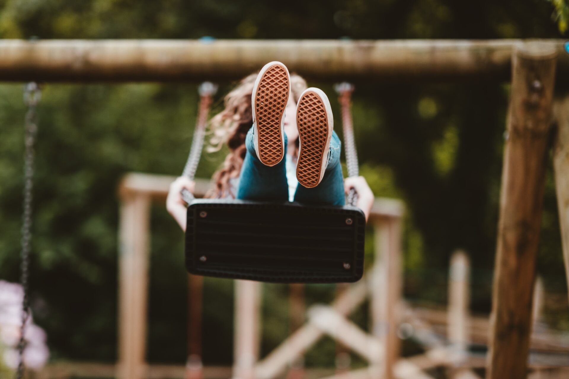 girl on a swing with her feet kicking the air