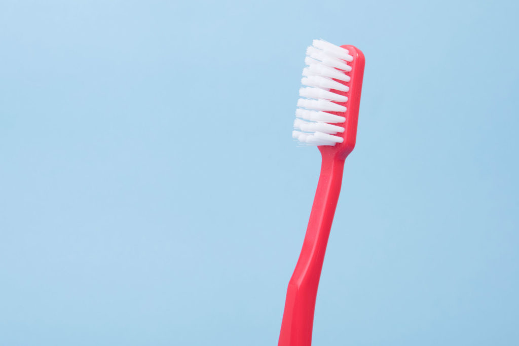 red toothbrush on blue background