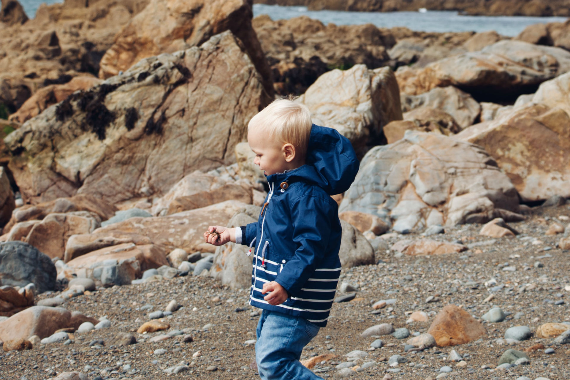 little boy standing on rocks