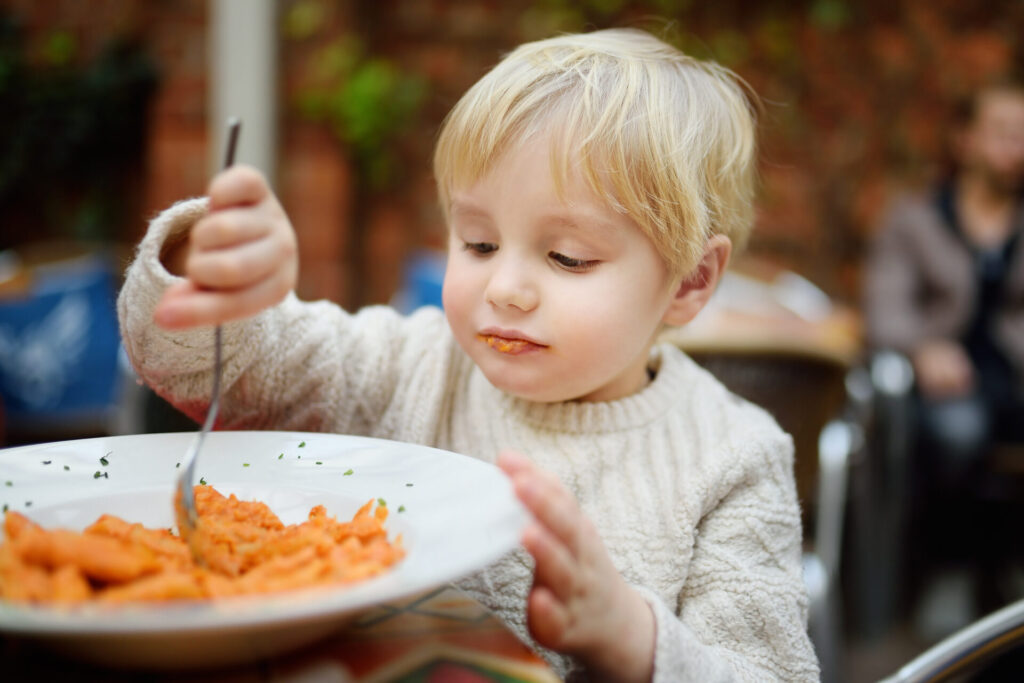 Should Restaurants Have the Right to Ban Kids? Child eating a plate of pasta