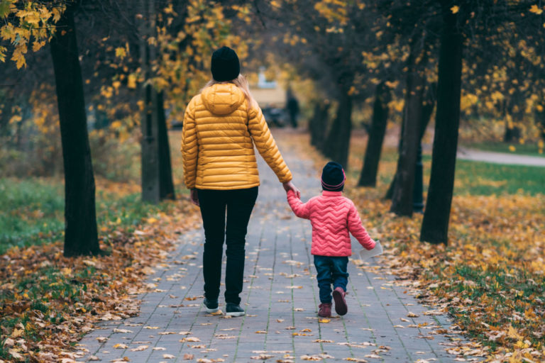 should you increase how often you walk your kids to school? a mother and child walking down a path in the fall
