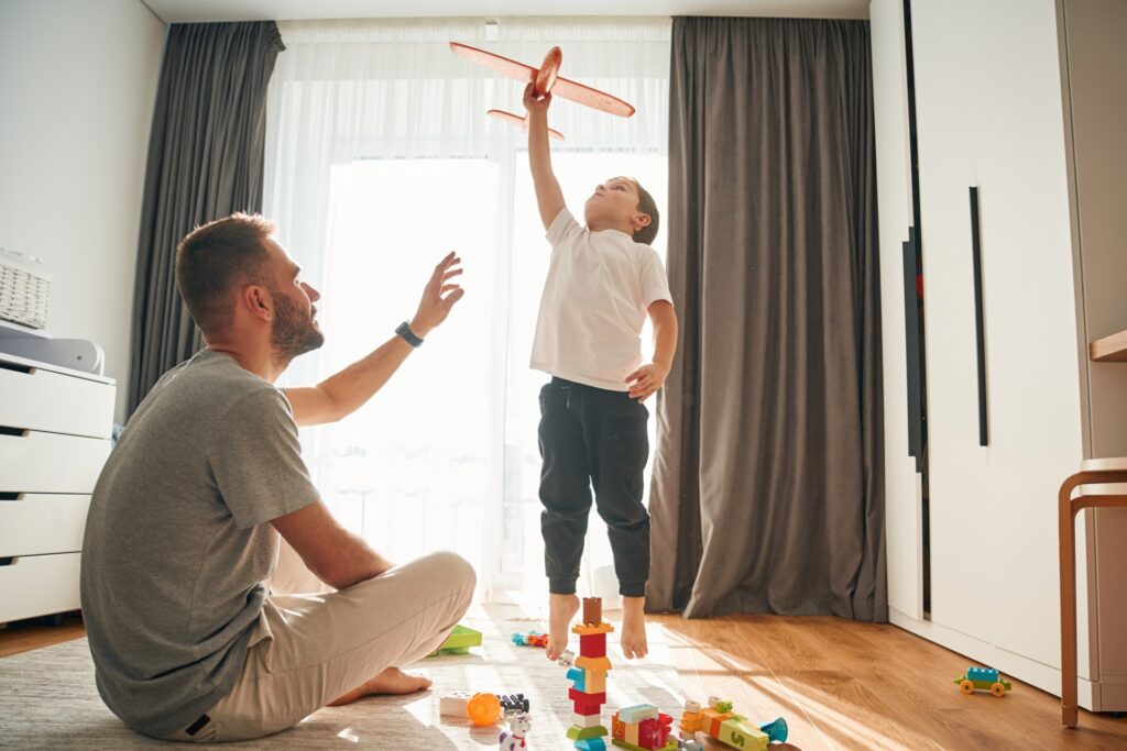 Father and child have indoor play with blocks and toys