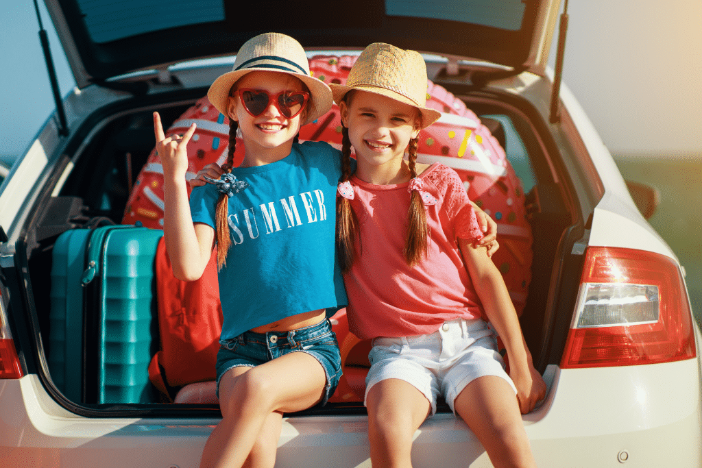 girls in the trunk of the car ready for a summer road trip