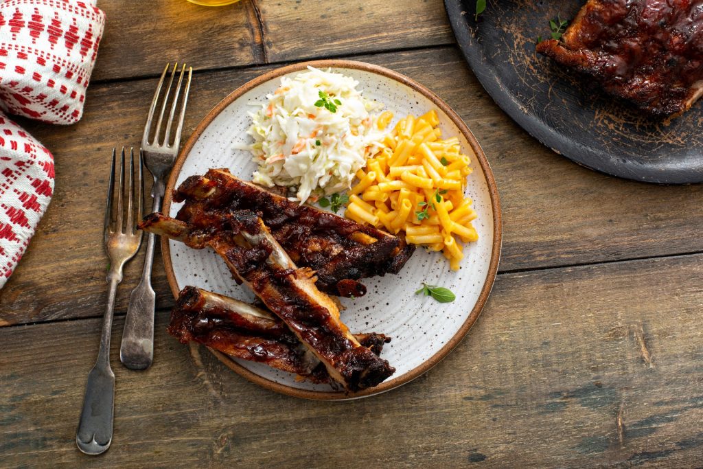 plate of ribs with mac and cheese and coleslaw