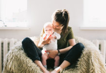 Is baby talk good for babies? mother holding her baby on a sheepskin-covered chair