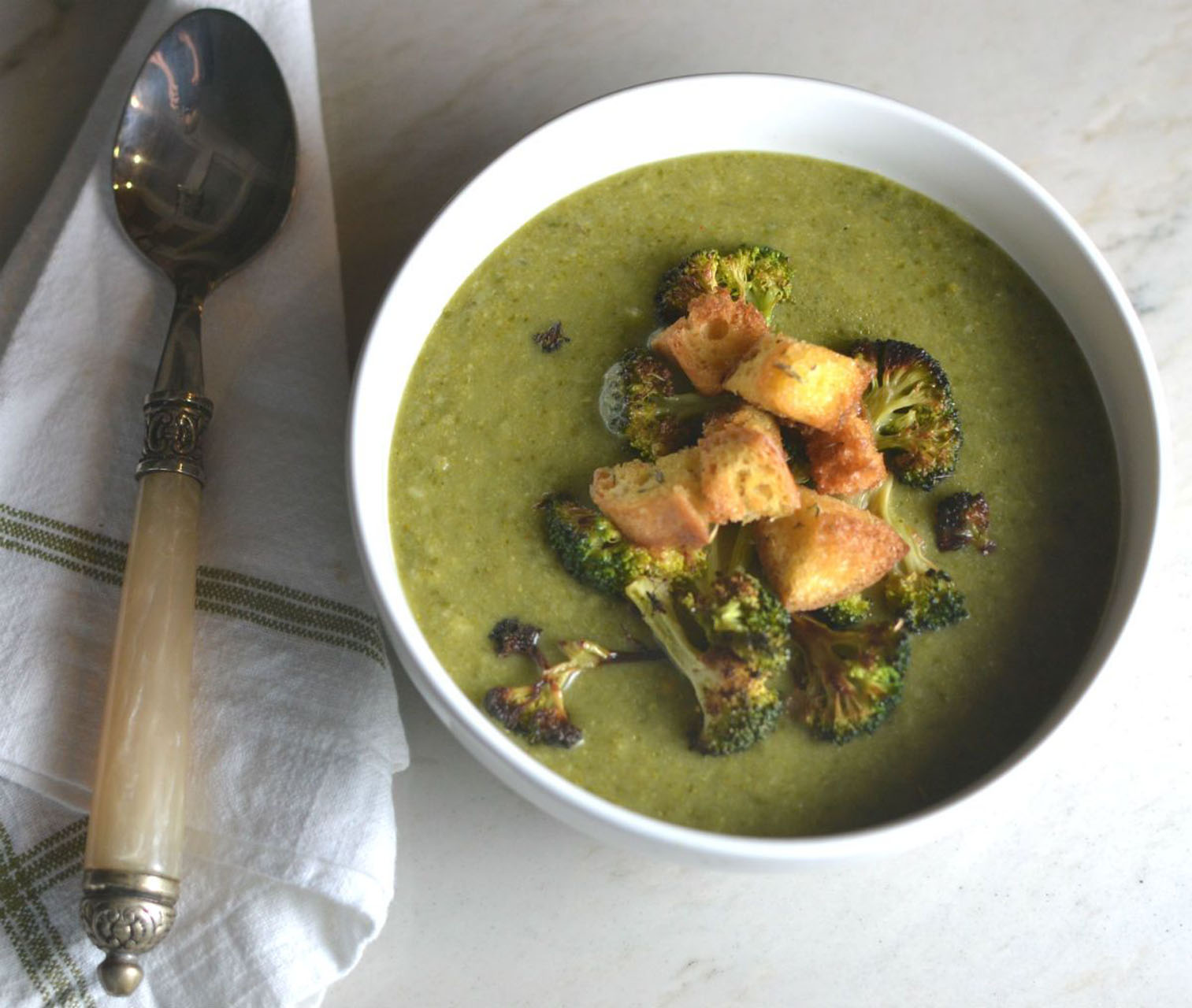bowl of broccoli soup with crispy croutons on top