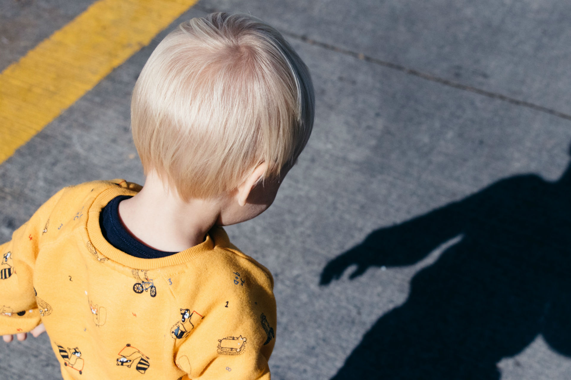 toddler outside looking at shadow