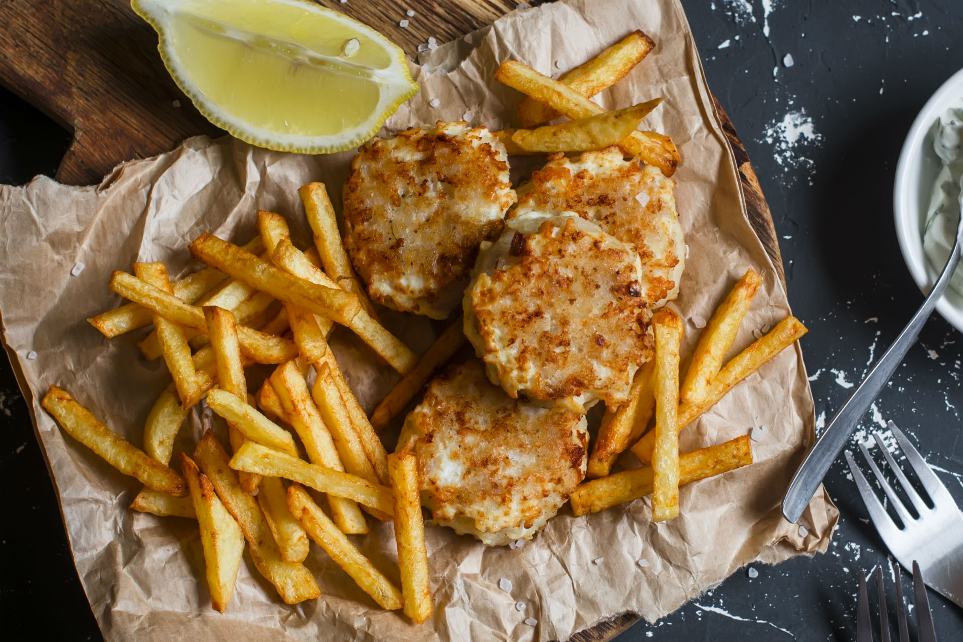 baked fish and chips with lemon wedge