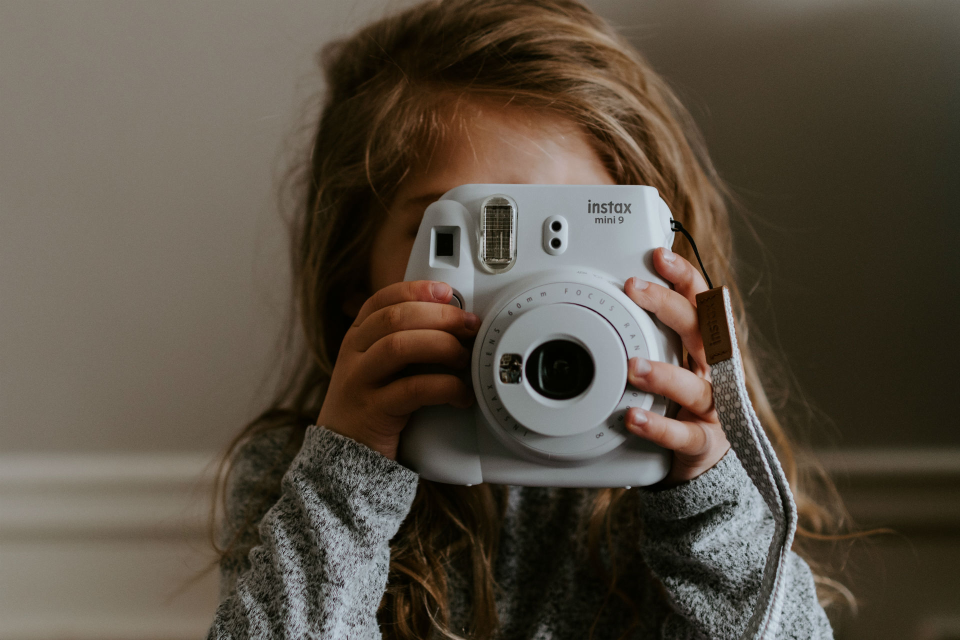 little kid taking a photo with an instant camera