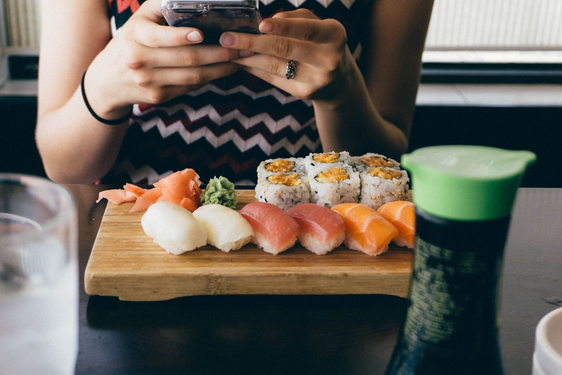 woman sitting in front of a spread of sushi