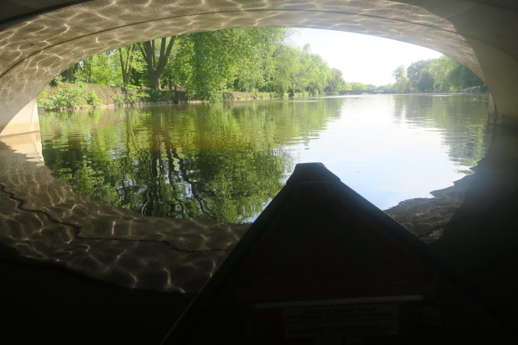 canoeing under a bridge on still water