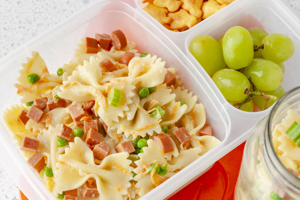 lunch container with pasta salad, crackers and grapes
