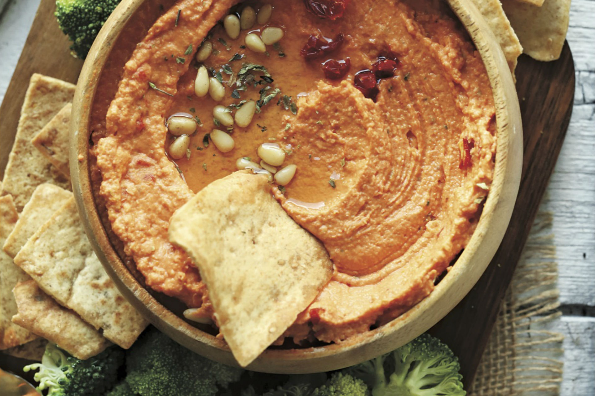 bowl of hummus with bread and veggies to dip