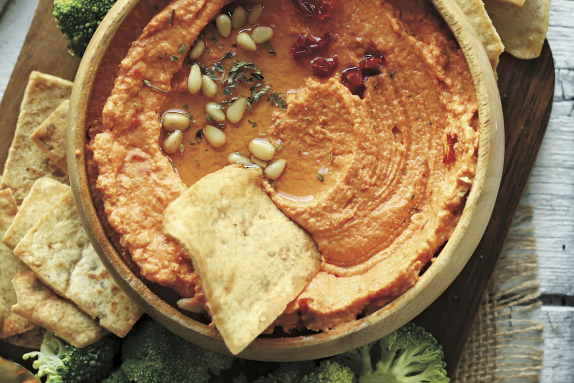 Bowl of hummus with bread and veggies to dip