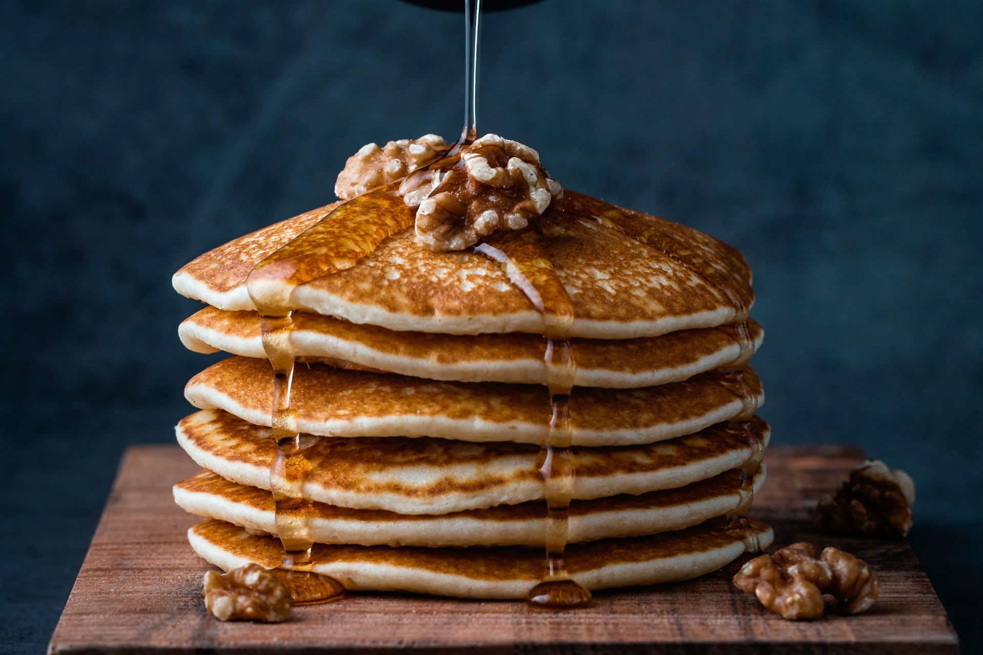 stack of pancakes with walnuts and syrup