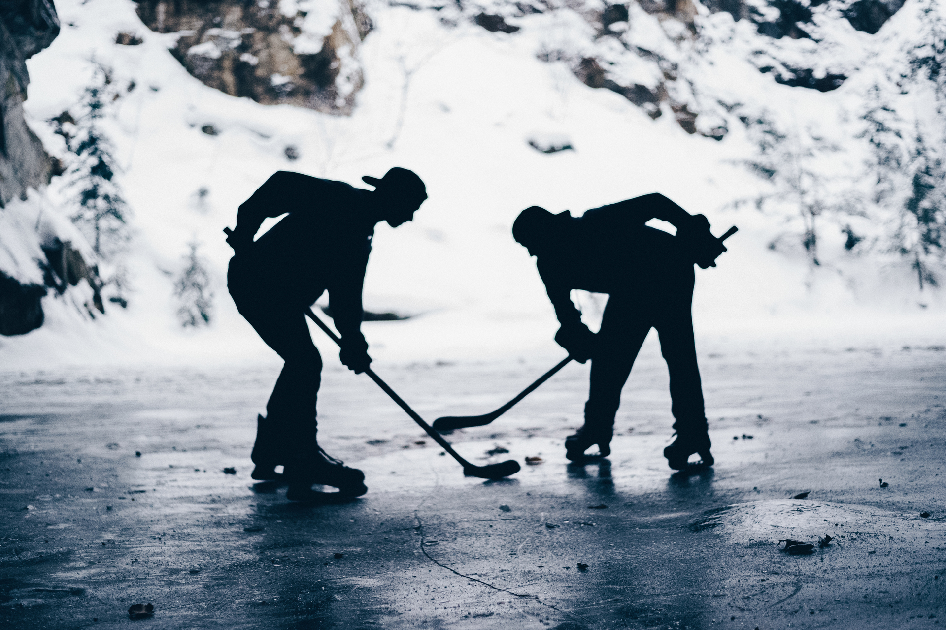 Black-and-white image of two boys playing shinny hockey