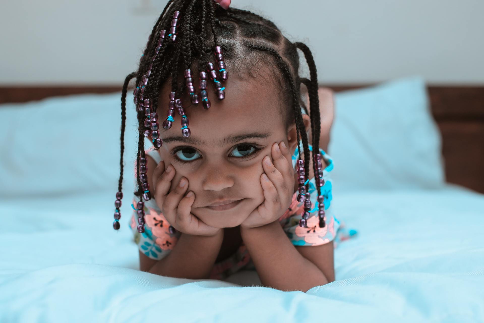 Little girl with braids looking sadly at the camera