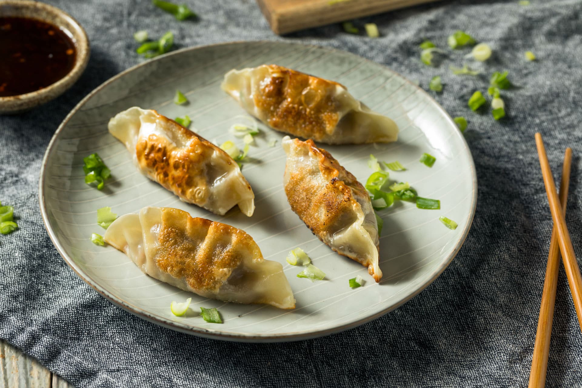 potstickers on a plate with scallions