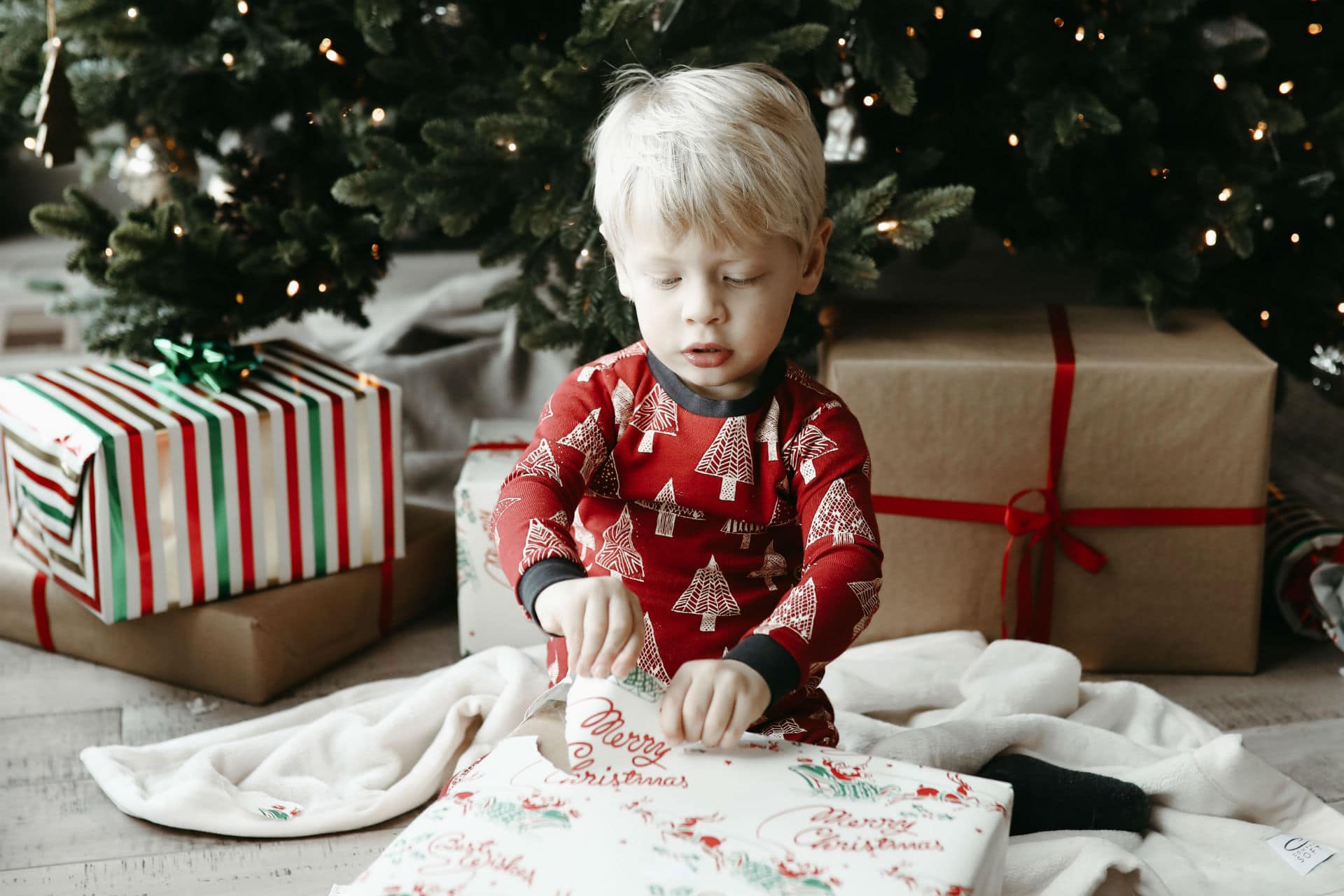 little boy opening a christmas gift