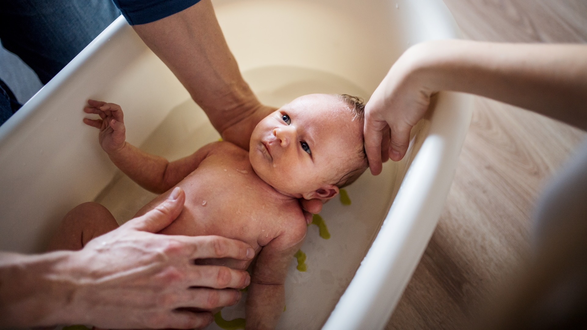 Parents bathing newborn