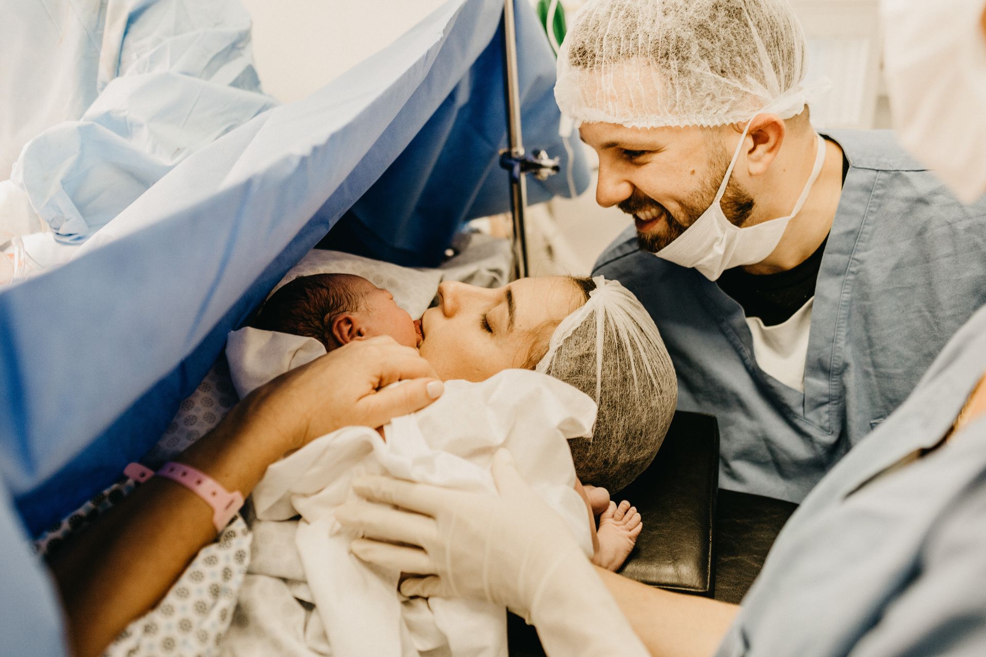 Dad looking on as baby brought to Mom after C-section