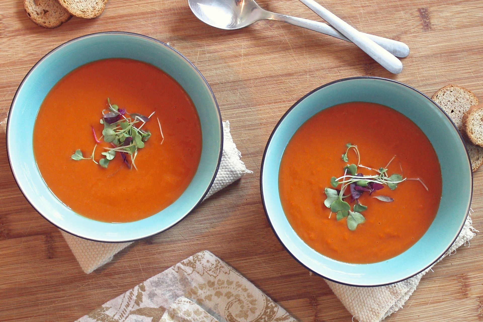 Two bowls of tomato soup side by side
