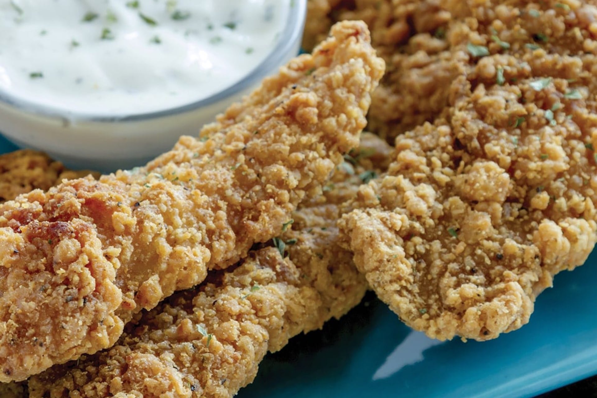 Plate of chicken fingers with ranch dressing to dip