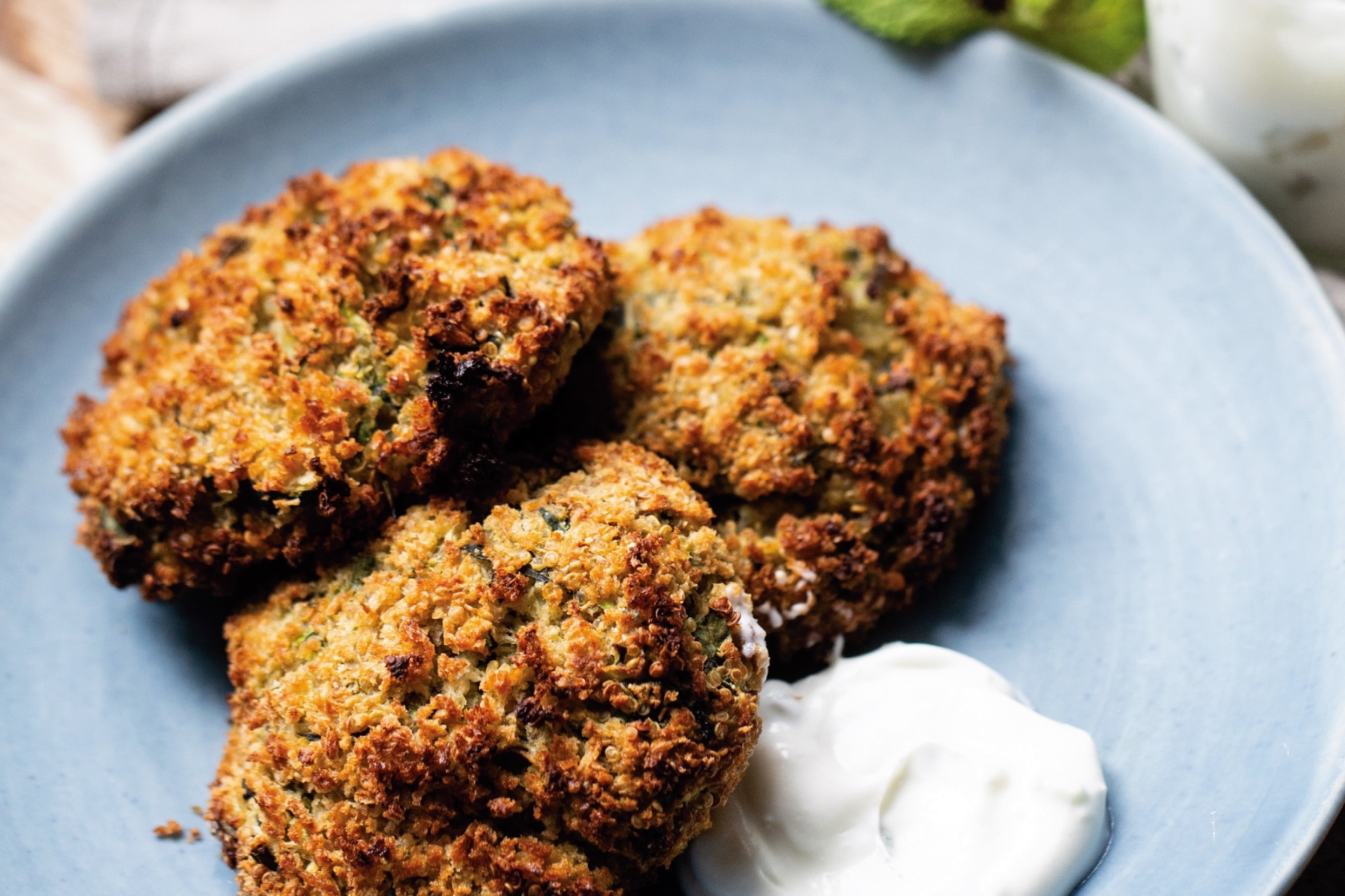 Zucchini fritters on a plate with creamy sauce to dip