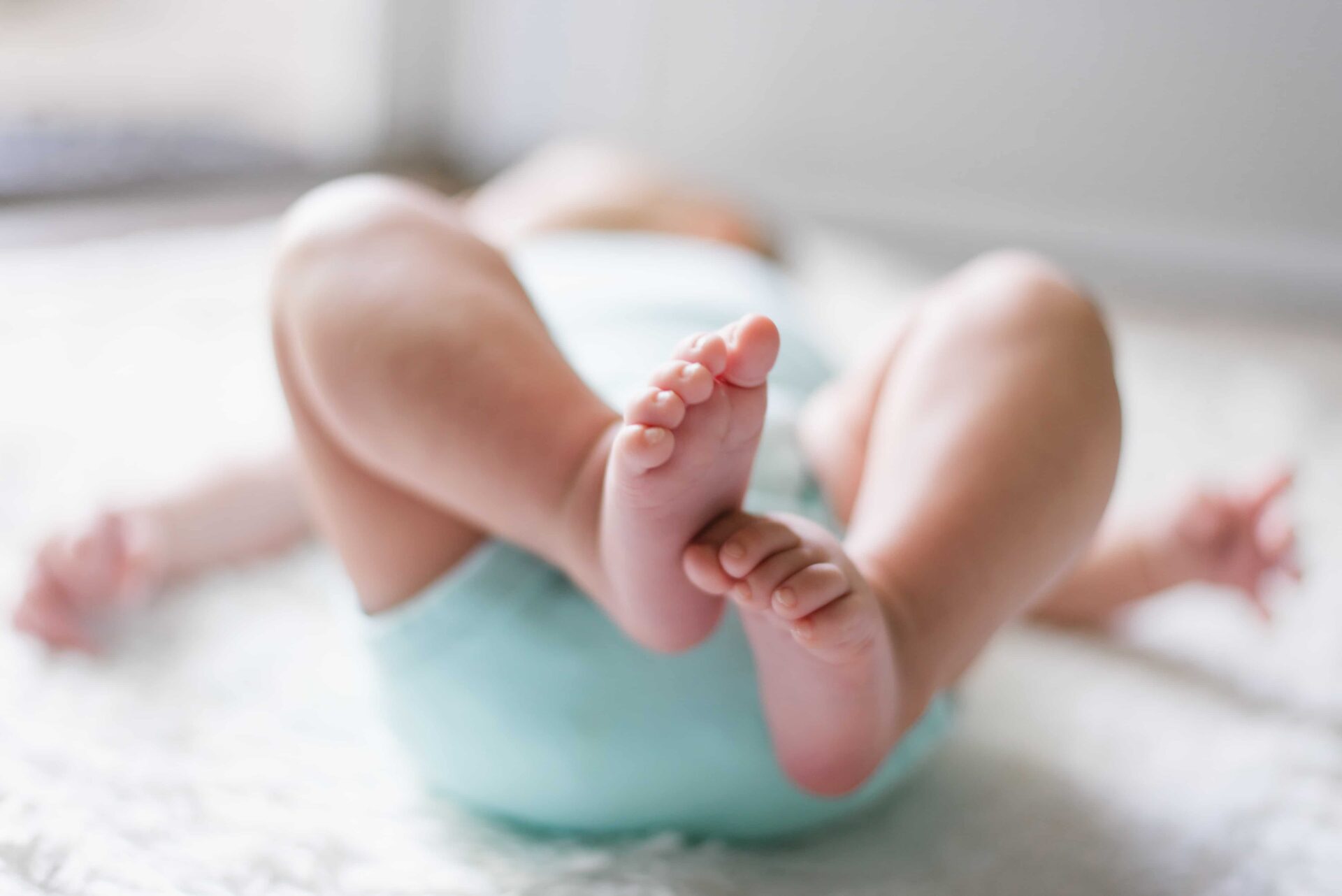 baby laying with feet in the air to show small toes