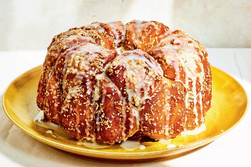 challah monkey bread on a plate with glaze dripping down