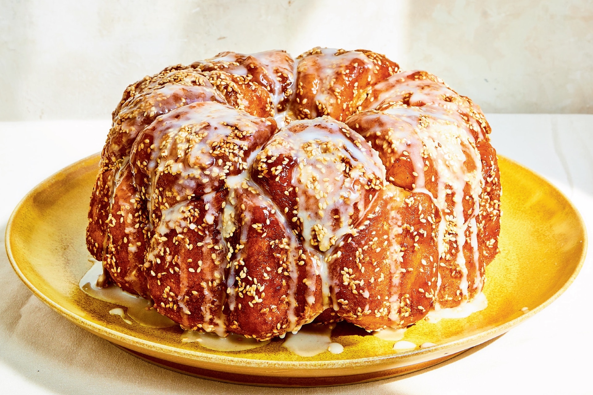 Challah monkey bread on a plate with glaze dripping down