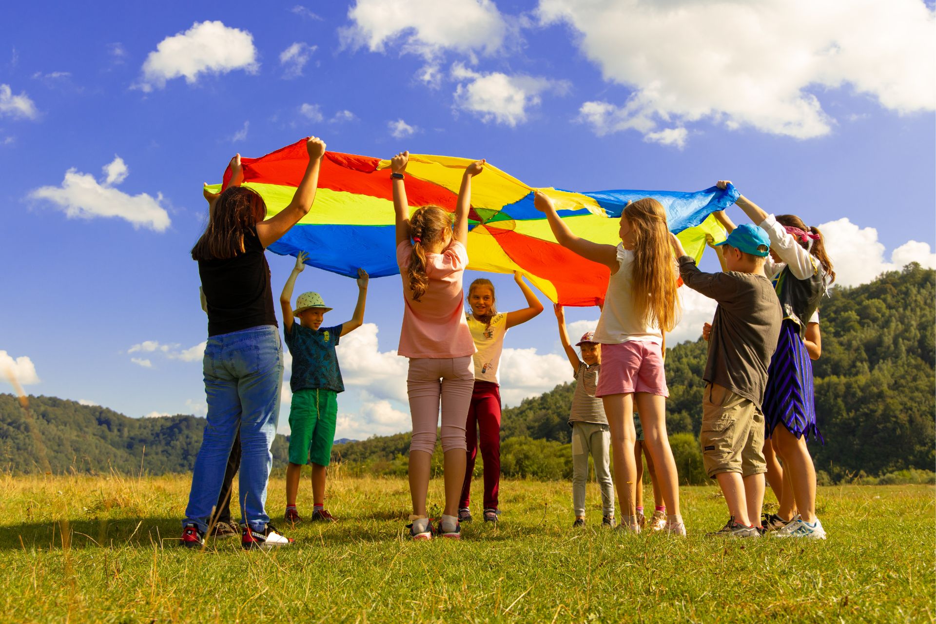 Kids playing with colourful parachute