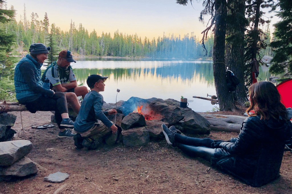 family at a campfire on a camping trip roasting marshmallows