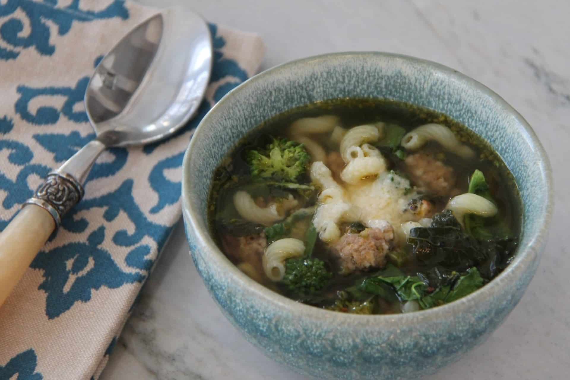 bowl of brothy soup studded with sausage crumbles, elbow pasta and broccoli