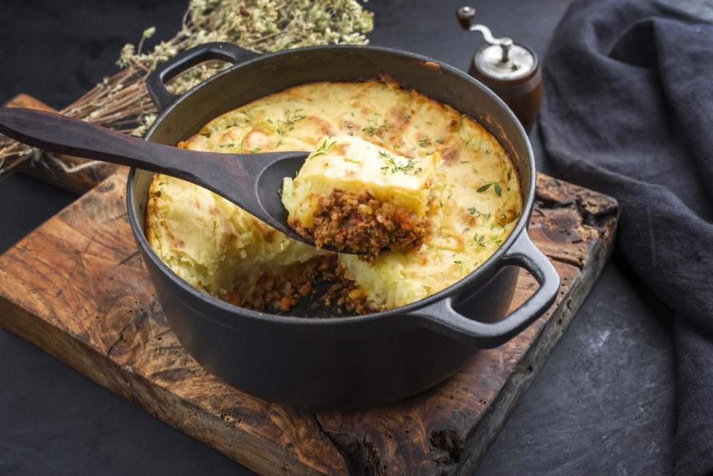 Butternut squash-topped shepherd's pie on a moody background