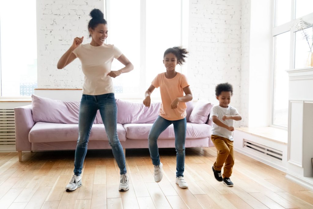 Parent dances happily with children, budget-friendly and screen-free