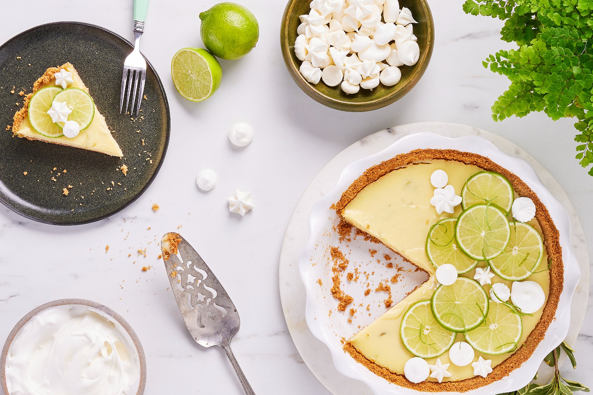 Zesty key lime pie sits on a table with garnishes