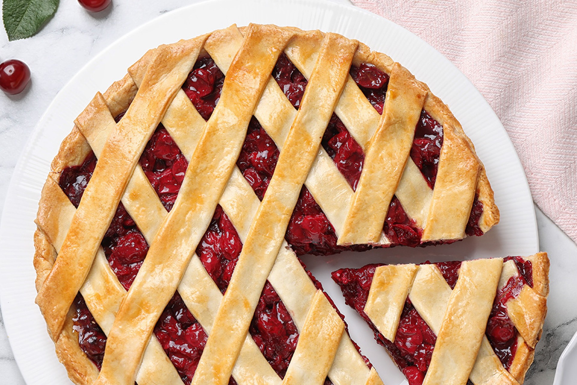 Deep dish cherry pie recipe on a plate with a tempting slice taken out
