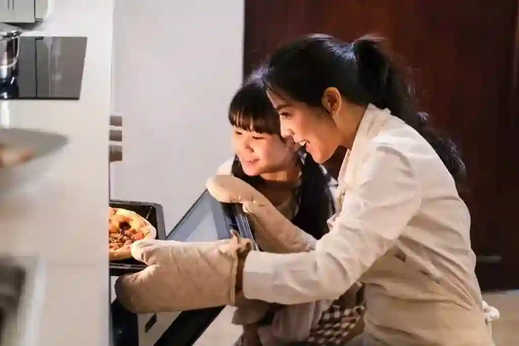 mother and child loading a homemade pizza into the oven after they upped their homemade pizza game