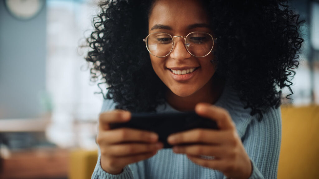 Black woman playing free phone games on a device
