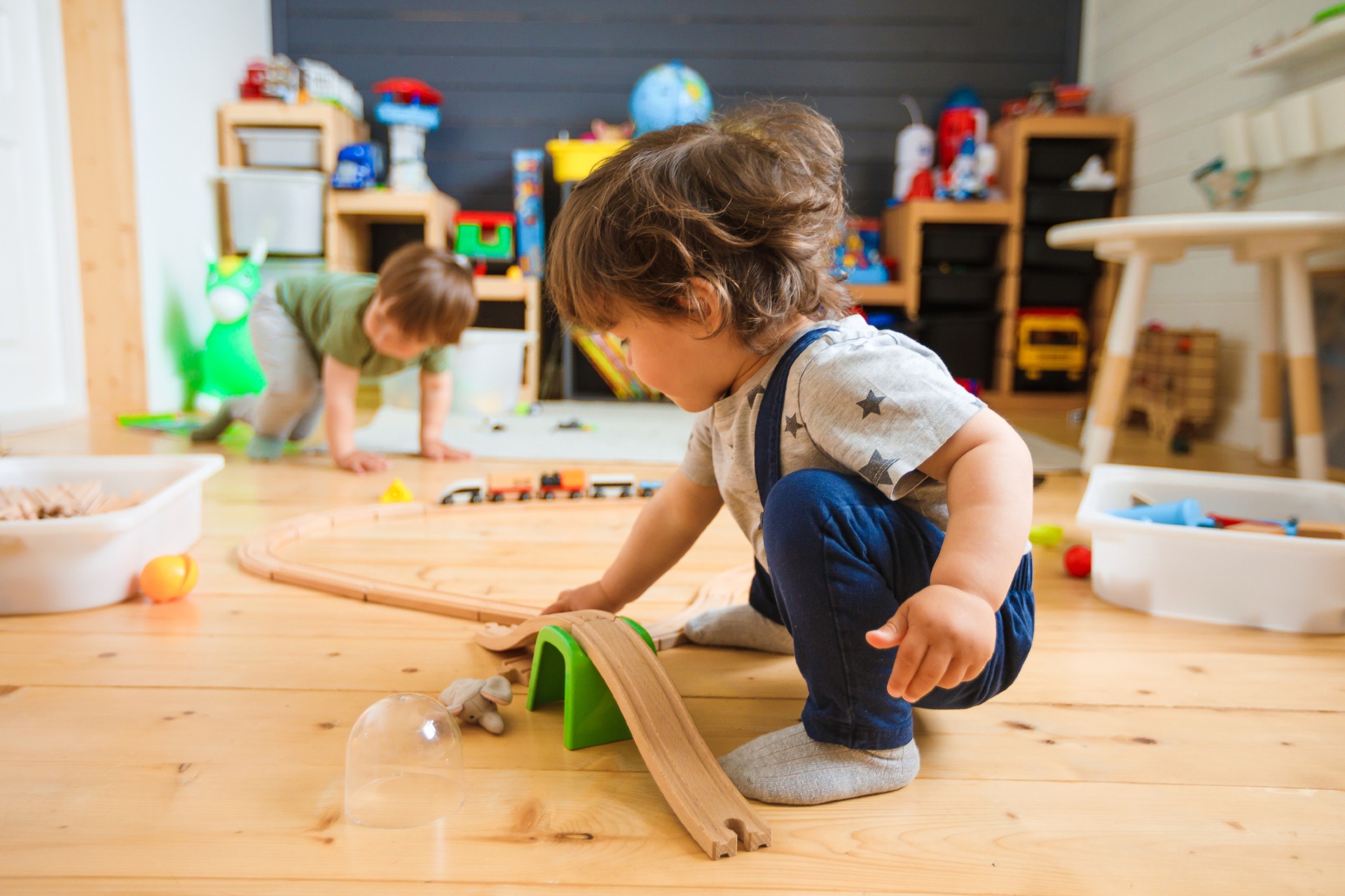 Father and two kids sit on the floor playing a boardgame